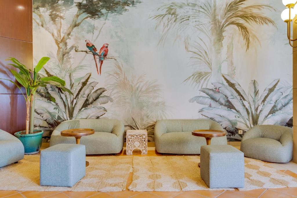 Mūsdienīgs un ērts atpūtas stūrītis Auramar Beach Resort ar tropisku sienu gleznojumu.