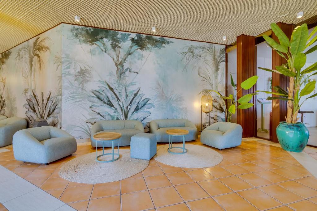 Mūsdienīgs viesnīcas Auramar Beach Resort interjers ar zālītēm un māksliniecisku sienu gleznojumu.