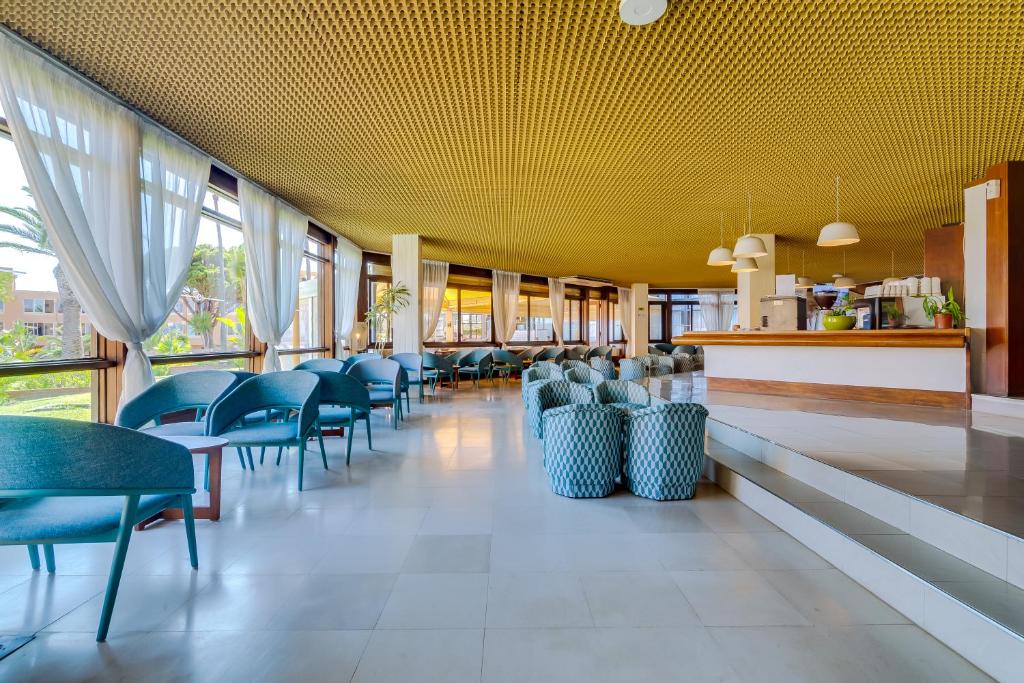 Auramar Beach Resort viesnīcas iekšējais bārs ar modernām mēbelēm un dabīgu apgaismojumu.