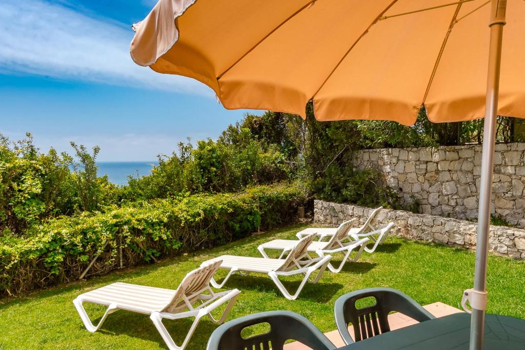 Viesnīcas Pestana Palm Gardens piekrastes atpūtas zona ar sauļošanās krēsliem.
