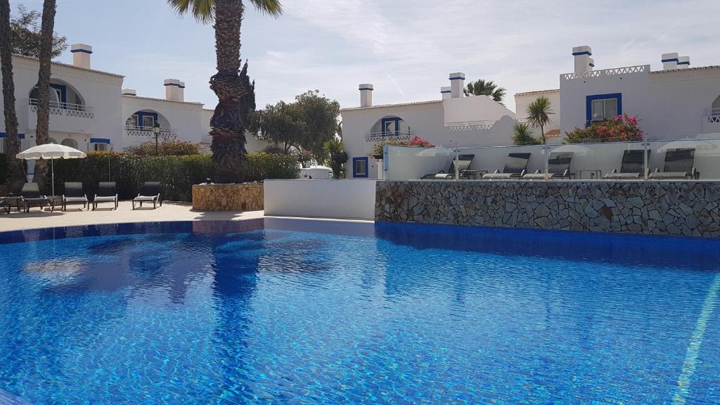 Pestana Palm Gardens Ocean & Golf Villas izcila peldbaseins ar palmām un saulessargiem