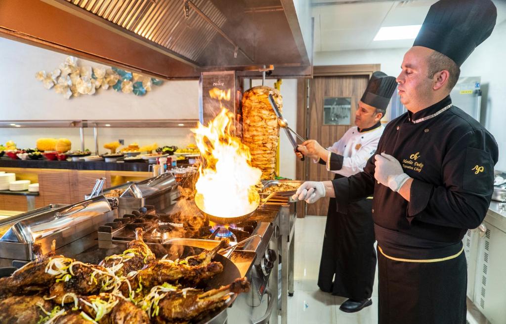 Šefpavāri gatavo gardēžus ēdienus CAMPUS HILL HOTEL virtuvē