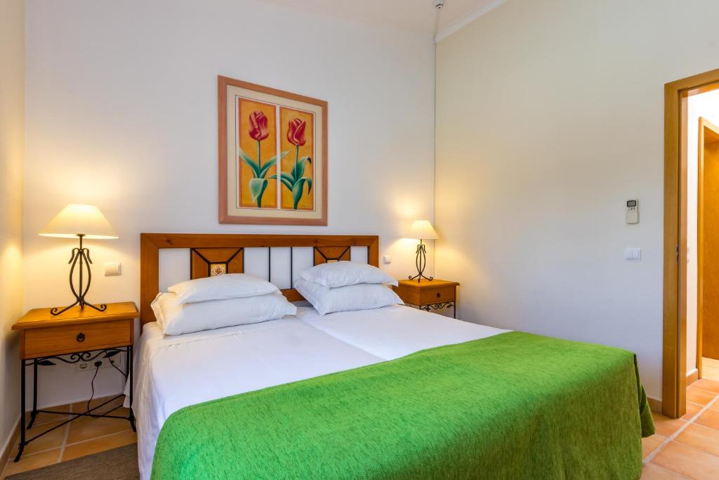 Numurs viesnīcā Pestana Palm Gardens Ocean & Golf Villas ar divām gultām un zaļu segu.