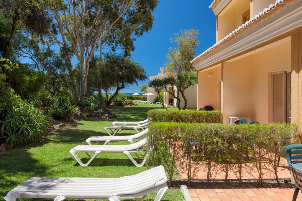 Pestana Palm Gardens Ocean & Golf Villas dārza zona ar saulessargiem un atpūtas krēsliem.