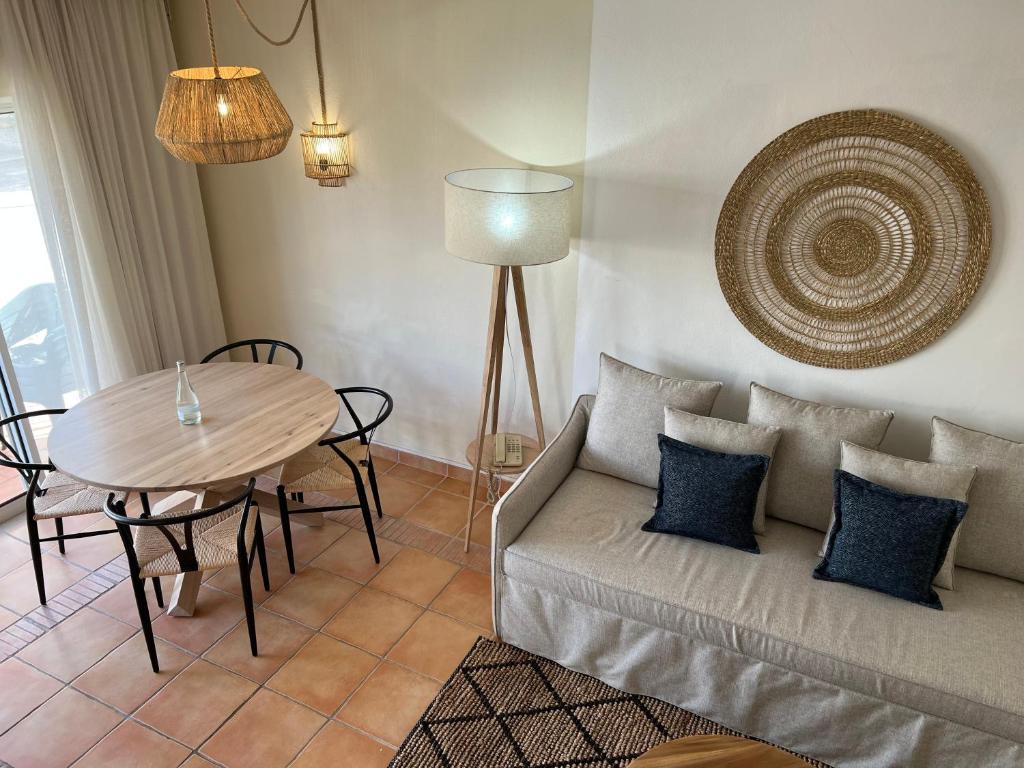 Mūsdienīgs dzīvojamais numurs ar ērtu dīvānu un ēdamgaldu viesnīcā Pestana Palm Gardens Ocean & Golf Villas.
