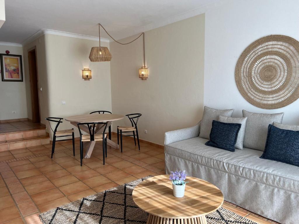 Mūsdienīgs viesnīcas numurs Pestana Palm Gardens Ocean & Golf Villas ar ērtu dīvānu un ēdamgald.