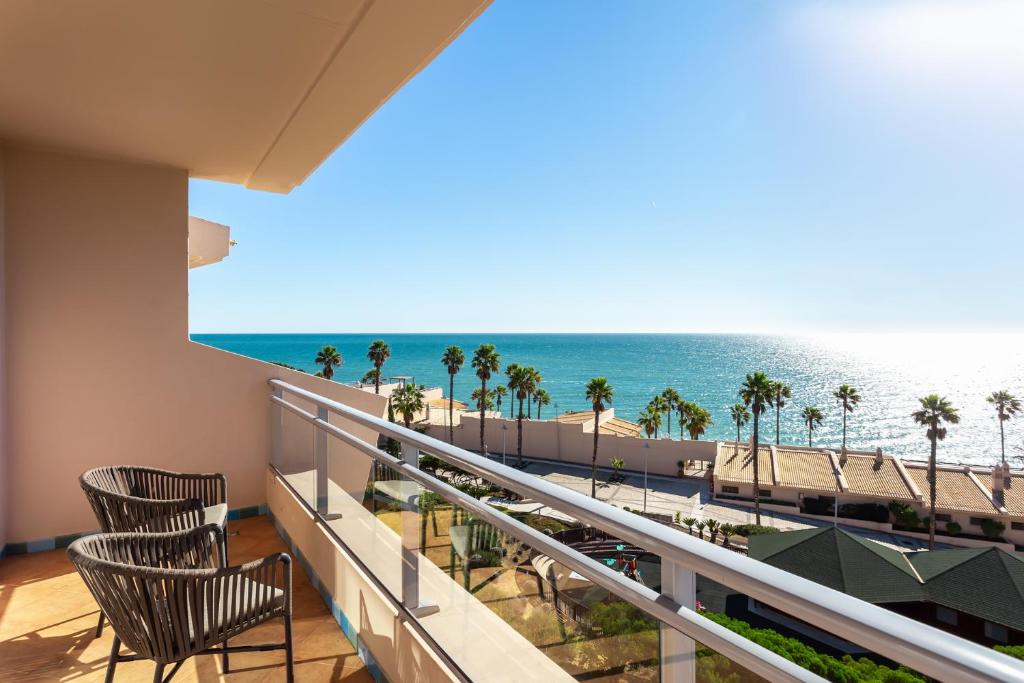 Skats no balkona uz jūru un palmām pie Grande Real Santa Eulalia Resort & Hotel Spa.