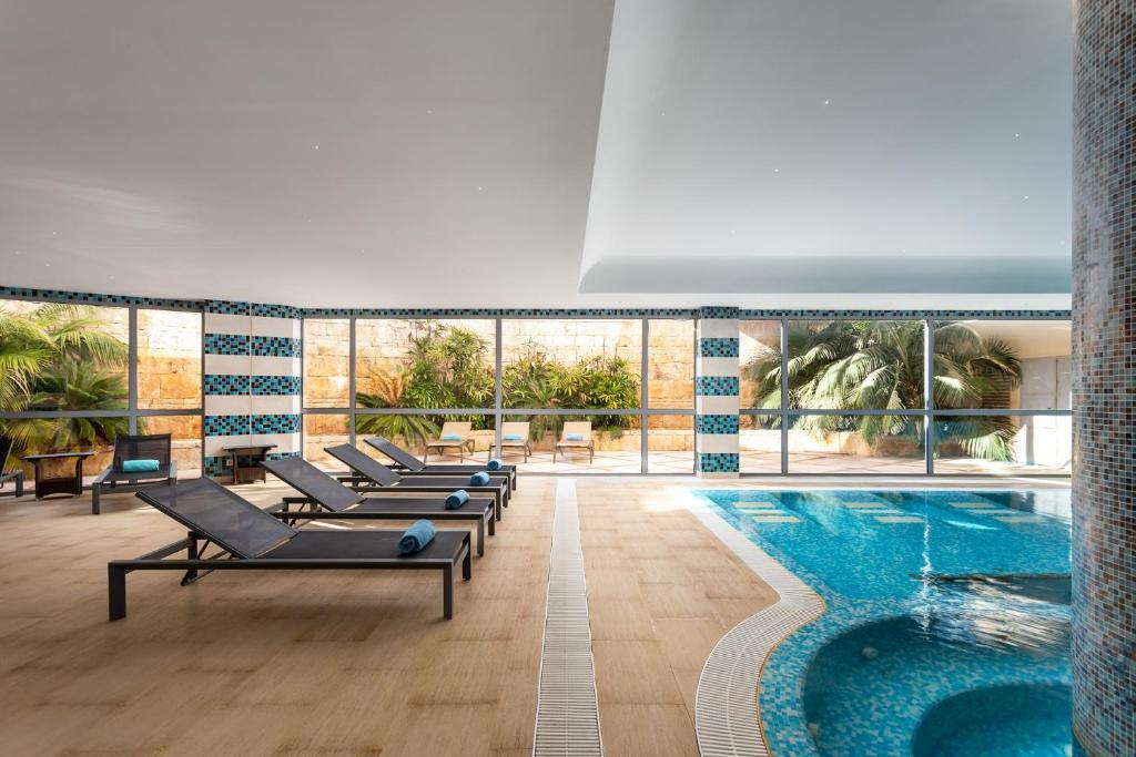 Relaksējošs iekštelpu baseins ar sauļošanās gultām Grande Real Santa Eulalia Resort & Hotel Spa