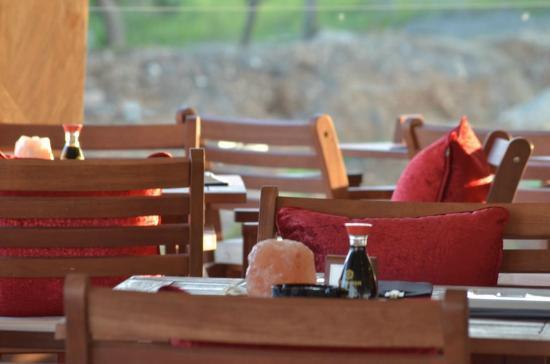 Restorāna terase ar sarkanām spilveniem Adams Beach viesnīcā.