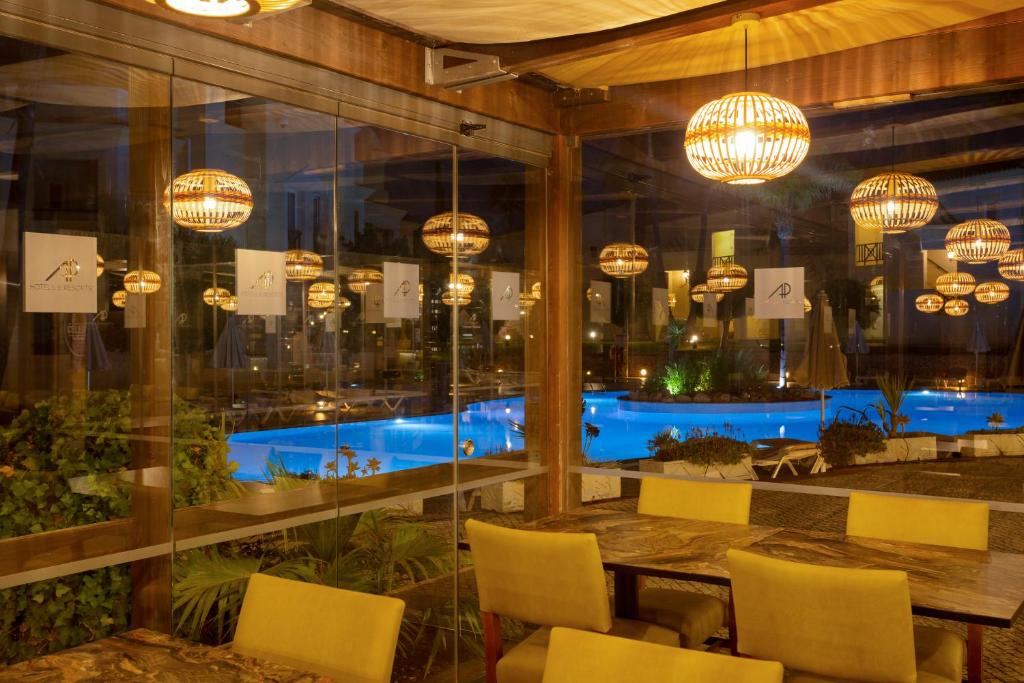 AP Adriana Beach Resort restorāns ar skatu uz baseinu naktī