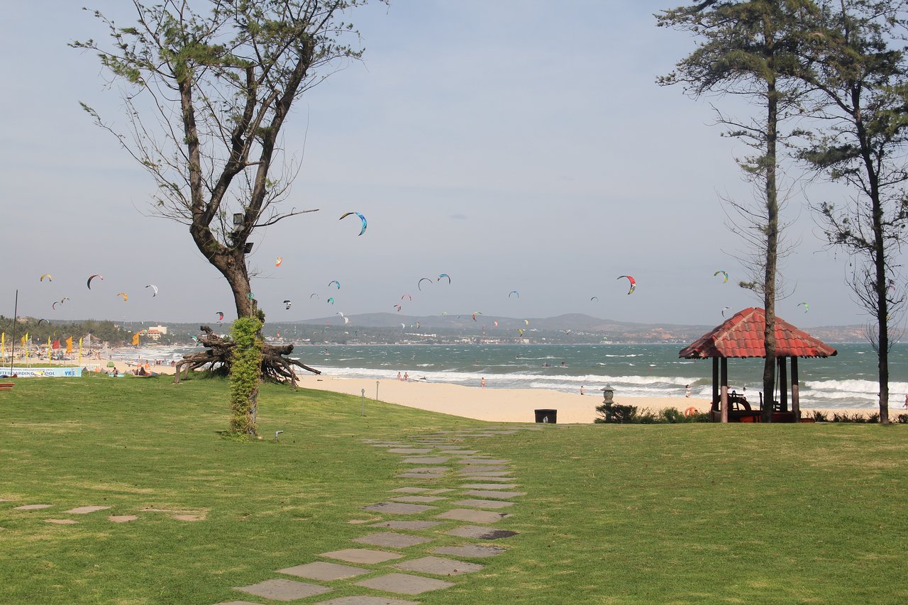 Ca Ty Resort pludmales skats ar kaitsērfinga pūķiem debesīs.