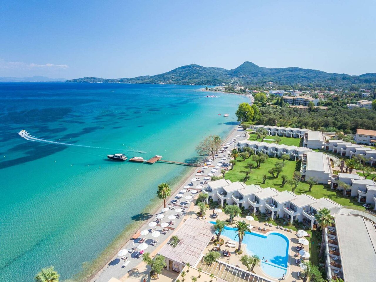 Skaista pludmales ainava ar zilo jūru, viesnīcu kompleksu un peldbaseinu. panoramic view with beach and pools