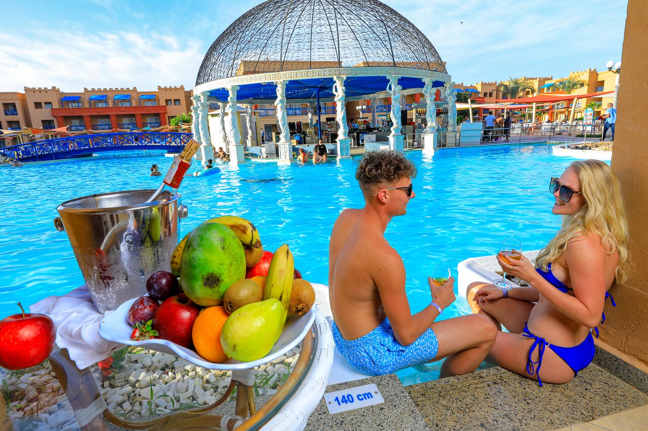 Pāris pie baseina Titanic Palace Resort ar augļiem un dzērieniem