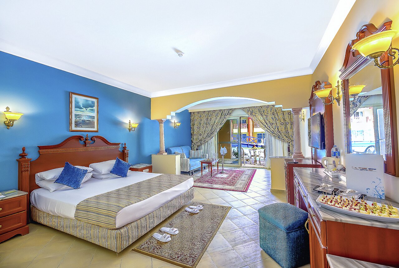 Numurs Titanic Palace Resort ar plašu gultu un viesistabu.