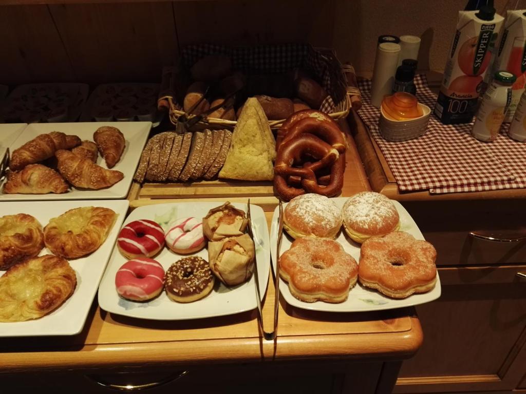 Brokastu galda klājs ar dažādām maizēm un konditorejas izstrādājumiem, tostarp kruasāniem, saldām maizītēm un cepumiem. Ideāla izvēle gardēžiem un saldumu mīļotājiem.