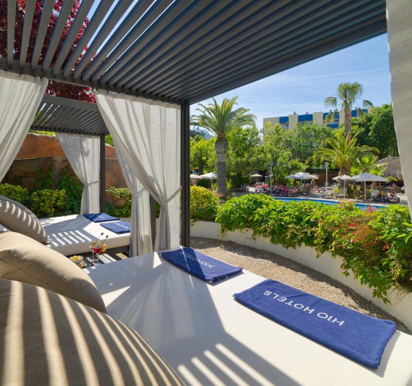 Relaksējoša atpūtas zona ar gultām un pludmales dvieļiem, skatoties uz peldbaseinu un tropisko dārzu. Ideāla vieta, lai izbaudītu saulainas dienas un atpūtu.