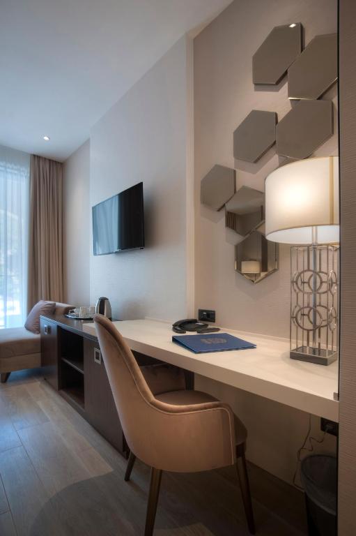 Mūsdienīgs viesnīcas numurs ar ērtu darba vietu, televizoru un stilīgu apgaismojumu. Interjers ir elegants ar modernām detaļām un gaišām krāsām.