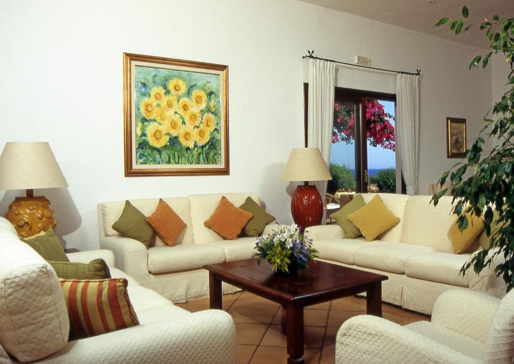 Hotel Stelle Marine viesistaba ar skatu uz dārzu un jūru.