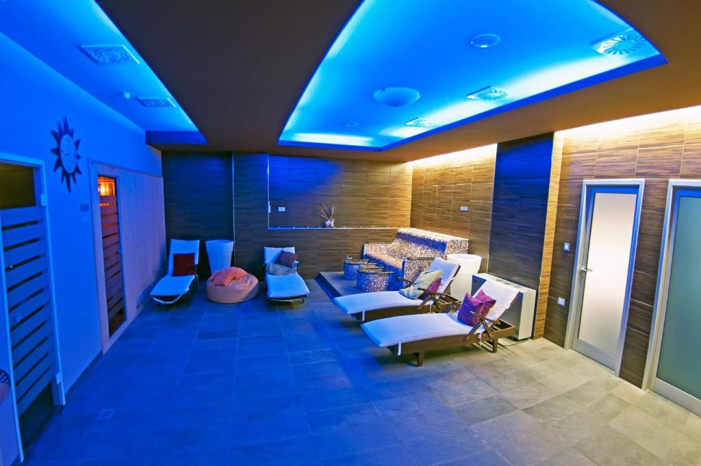 Mūsdienīga relaksācijas telpa ar zilu apgaismojumu, ērtām atpūtas krēsliem un mīkstām mēbelēm. Ideāla vide, lai atpūstos un izbaudītu mierīgu atmosfēru.