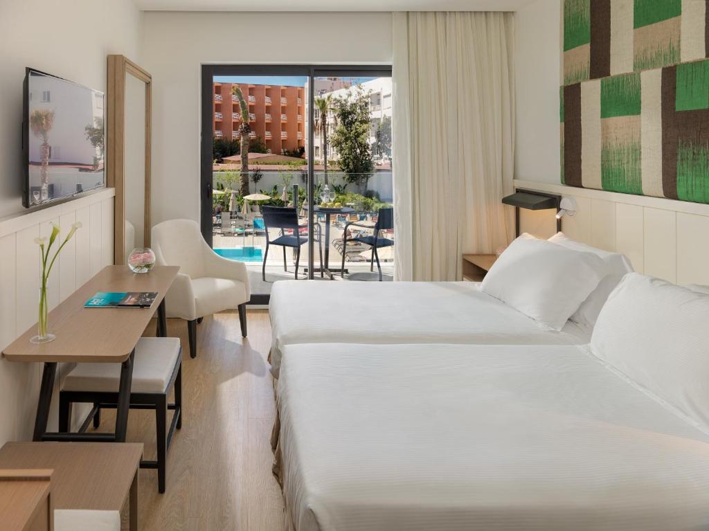 Mūsdienīgs viesnīcas numurs ar divām gultām, televizoru un skatu uz baseinu. Numurā ir gaismas krēsls un galds, kas nodrošina komfortu un ērtības.