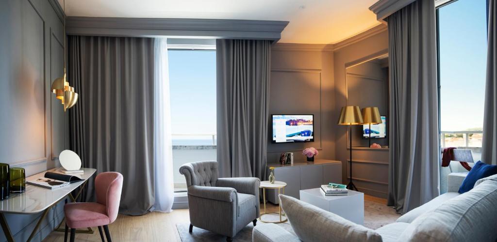 Mūsdienīgs viesnīcas numurs ar elegantu dekoru, gaišām krāsām un komfortablu mēbelējumu. Logi ļauj ieplūst dabiskai gaismai un piedāvā skatu uz ārpusi.