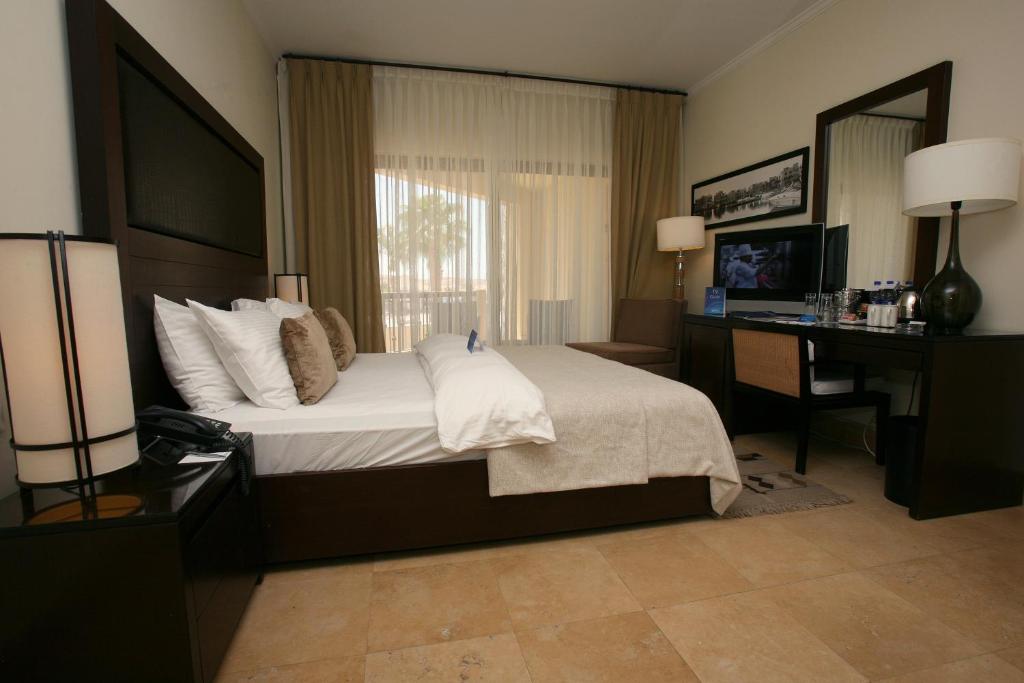 Mūsdienīgs viesnīcas numurs ar plašu gultu, dabiskiem apgaismojuma avotiem un ērtu rakstāmo, kas nodrošina komfortu un relaksāciju.