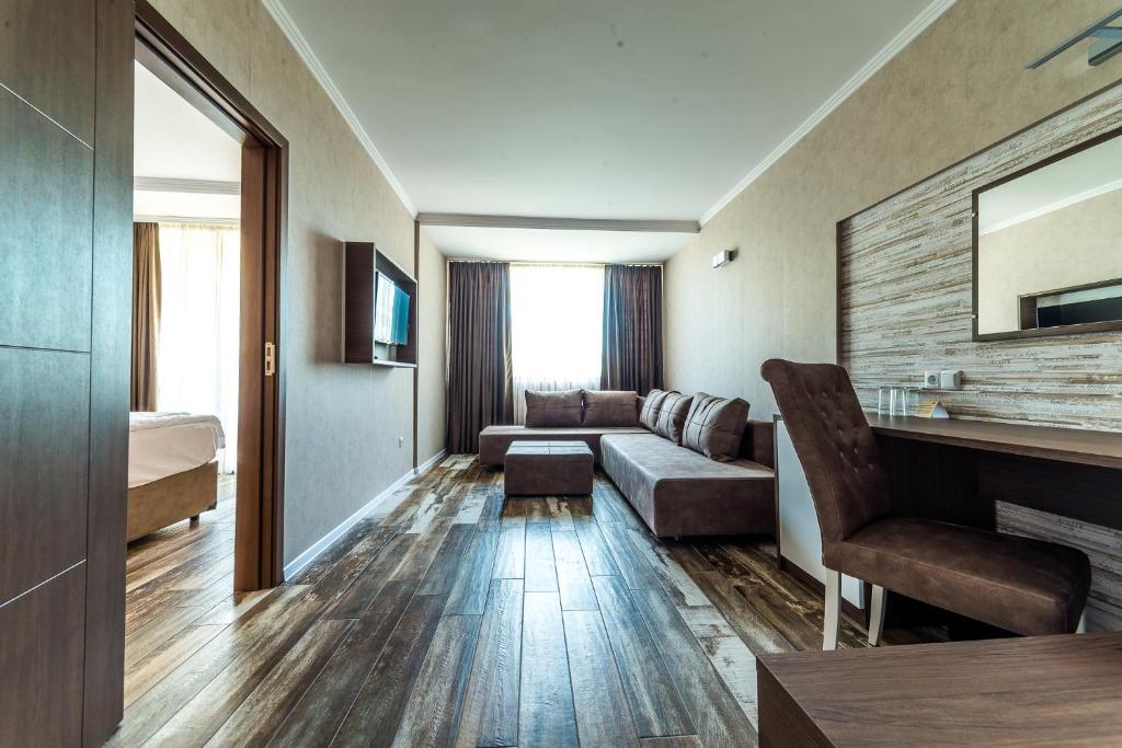 Mūsdienīgs viesnīcas numurs ar ērtu dīvānu, rakstāmgaldu un televizoru. Gaismas un koka grīdas radījušas siltu atmosfēru.