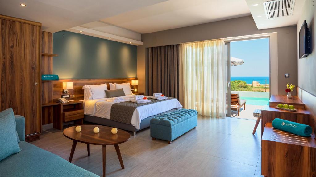 Moderns viesnīcas numurs ar skatu uz jūru, iekārtots ar ērtu gultu, dīvānu un koka mēbelēm. Lielas logus piepilda dabiska gaisma, radot patīkamu atmosfēru.