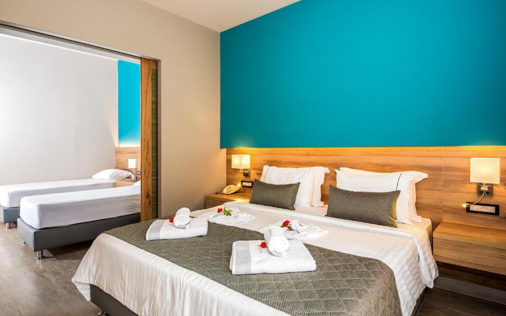 Mūsdienīgs viesnīcas numurs ar divām gultām, gaišām krāsām un dekoratīvām detalizācijām. Numurā ir ērti spilveni, gaismas un koka akcenti, radot mājīgu atmosfēru.