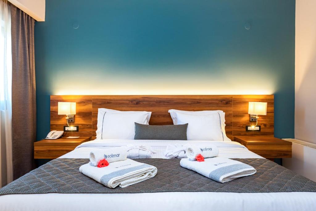 Mūsdienīgs viesnīcas numurs ar ērtu gultu, gaišām gultas veļām un dekoratīviem dvieļiem. Sienas ir krāsotas gaišā zilā tonī, radot relaksējošu atmosfēru.