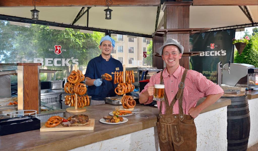 Divi vīrieši stāv pie bāra, kurā ir redzamas pārslas un alus. Viens vīrietis valkā šefpavāra uniformu un tur pārslas, bet otrs, ģērbies tradicionālā tērpā, smaida un tur alus kausu. Fonā redzams "Beck's" zīmolplakāts.