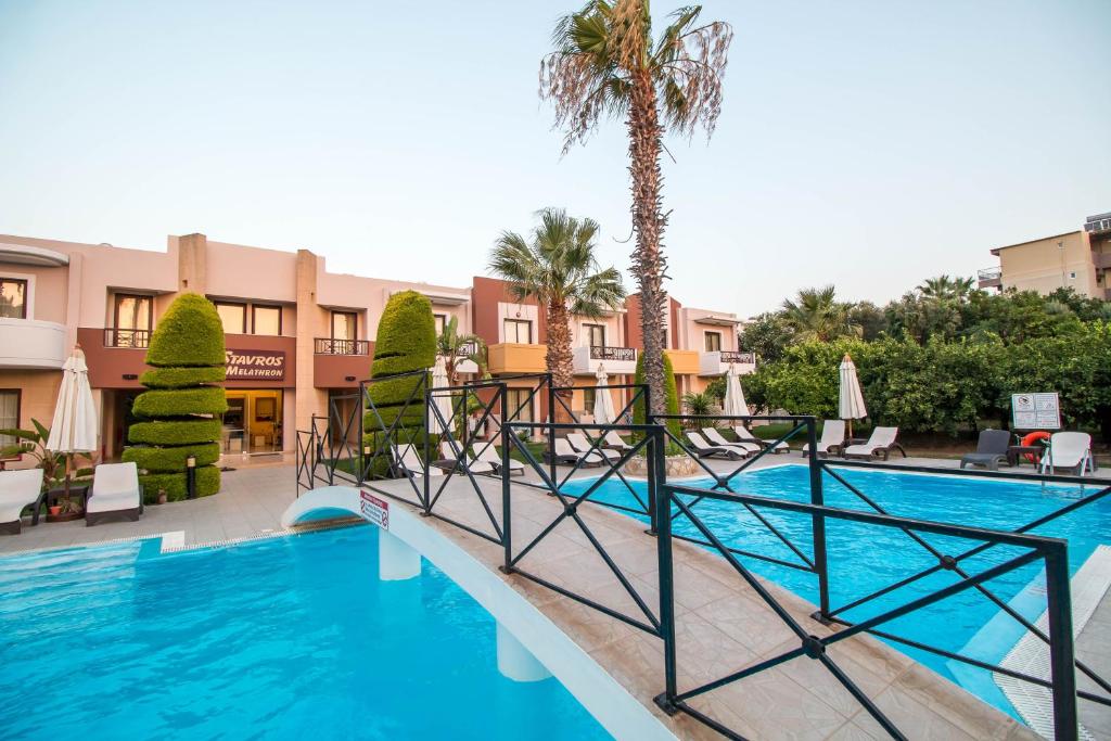 Viesnīcas baseins ar tiltiņu un apkārtējiem palmām, kas rada relaksējošu atmosfēru. Apkārt ir saulessargu un atpūtas krēslu zona, kas aicina uz atpūtu.