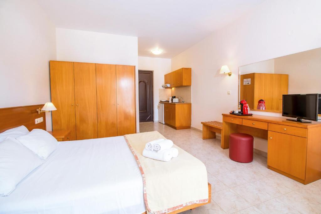 Mūsdienīgs viesnīcas numurs ar koka mēbelēm, gultu un virtuvi, kas aprīkota ar nepieciešamajām ierīcēm. Numurā ir televizors un spogulis, radot patīkamu atmosfēru.