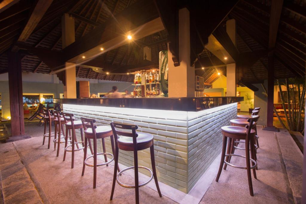 Mūsdienīgs bārs ar stilīgu apgaismojumu un koka krēsliem. Bāra lete ir veidota no gaišām flīzēm, radot siltu un viesmīlīgu atmosfēru.