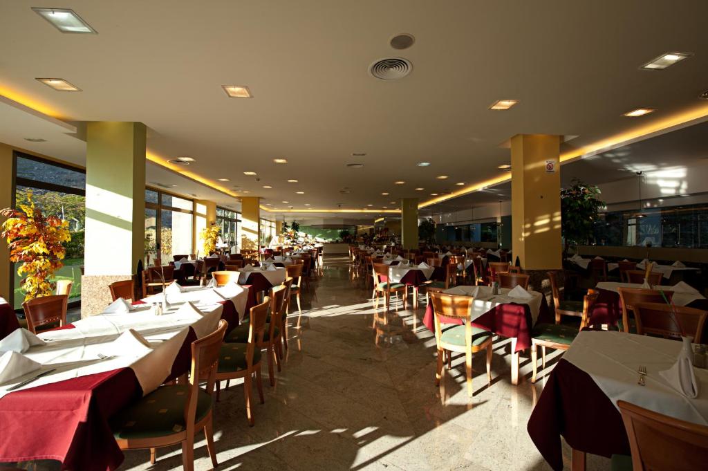 Mūsdienīgs restorāns ar plašu telpu, gaišu apgaismojumu un eleganti klātiem galdiem. Dabas gaisma plūst caur logiem, radot patīkamu atmosfēru.