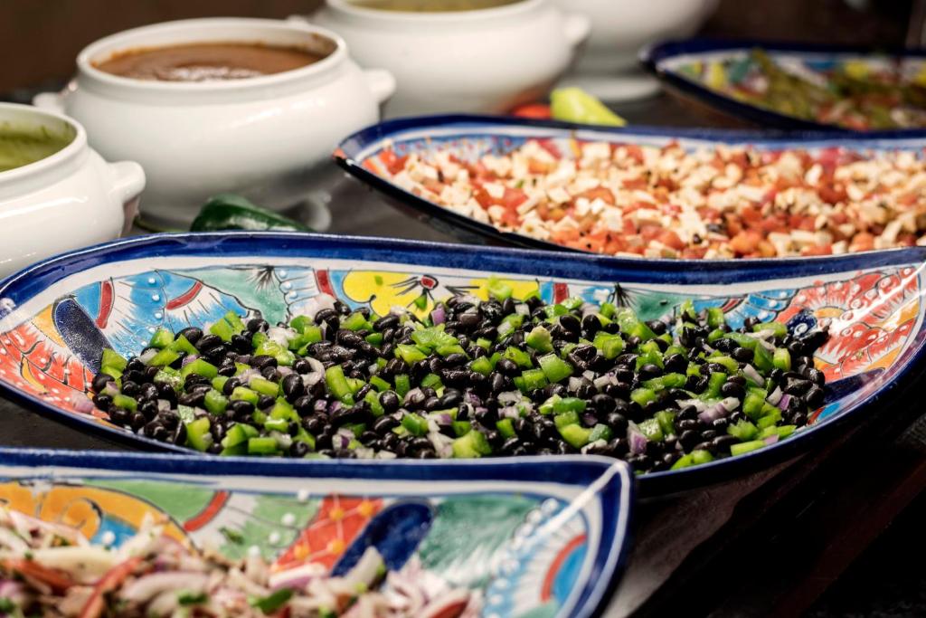 Krāsaini ēdieni uz dekoratīvām šķīvjiem, tostarp melnās pupiņas un zaļie pipari, kopā ar dažādām mērcēm. Ideāli piemērots, lai papildinātu meksikāņu ēdienus.