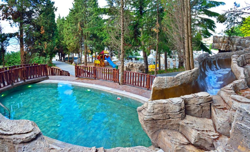 Skaists peldbaseins ar akmens struktūrām un ūdens slidkalniņu, ko ieskauj zaļi koki un bērnu rotaļu laukums. Ideāla vieta atpūtai un izklaidei.