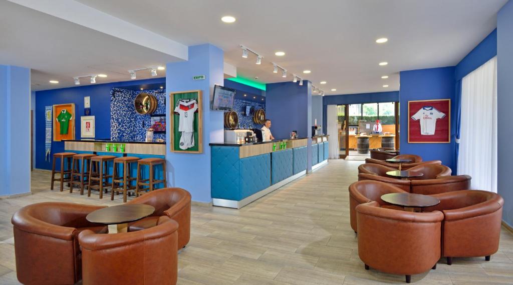 Mūsdienīgs bārs ar brūnām ādas krēsliem un koka galdiem, rotāts ar futbola formas tērpiem un zilu sienu. Viegli izgaismots, ar bāra letēm un TV ekrāniem, kas rada patīkamu atmosfēru.