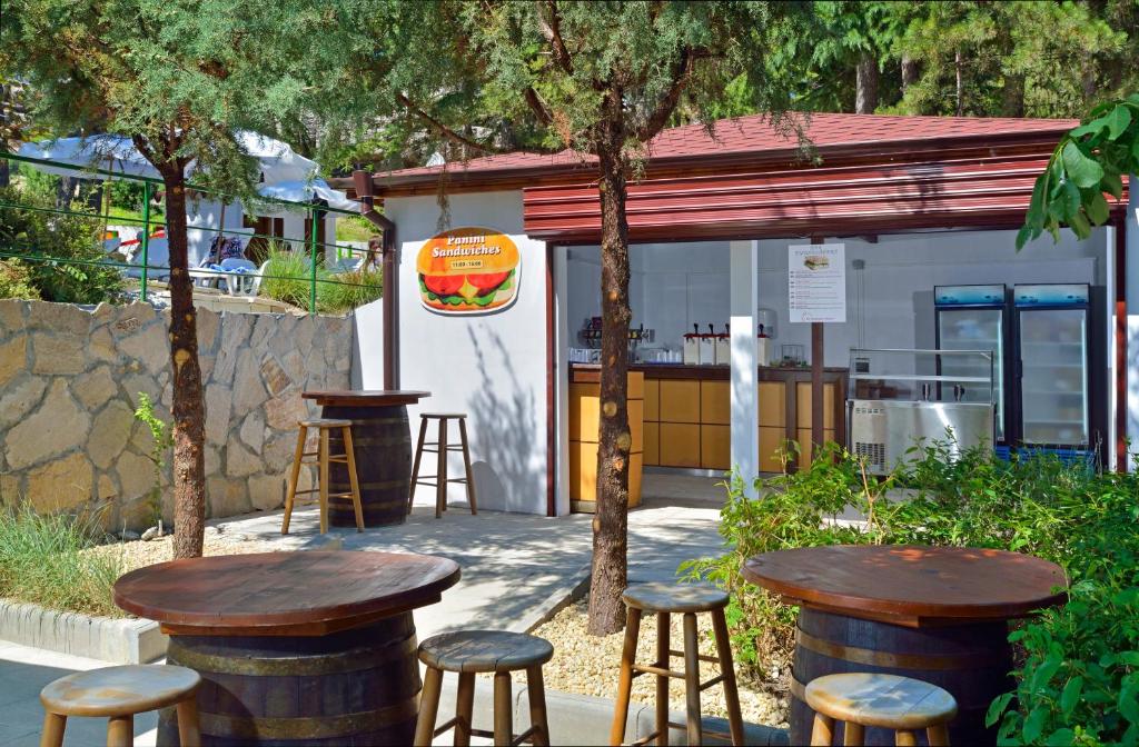 Kafejnīca ar atvērtu terasi un koka galdiem, kur pasniedz sviestmaizes un dzērienus. Apkārtējā vide ir zaļa un patīkama, radot relaksējošu atmosfēru.