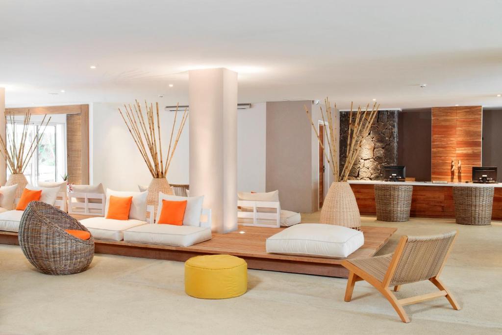 Mūsdienīgs viesnīcas reģistratūras interjers ar stilīgu mēbeļu un dabīgu elementu kombināciju, radot relaksējošu atmosfēru. Sēdvietas ir veidotas no dabīgām materiālu un spilveniem ar siltām krāsām.