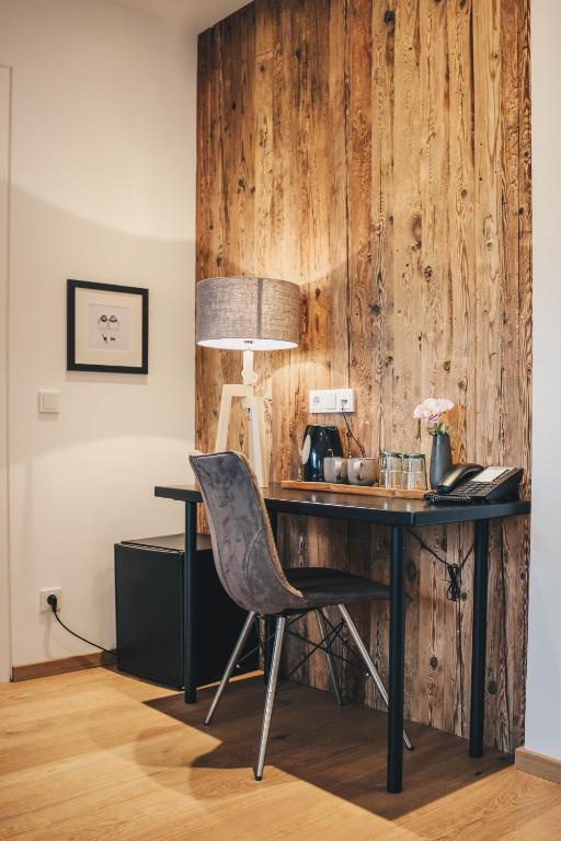 Mūsdienīgs darba stūrītis ar koka sienu, galdu un ērtu krēslu, apgaismojumu un kafijas automātu. Ideāls vieta produktīvai darbībai.