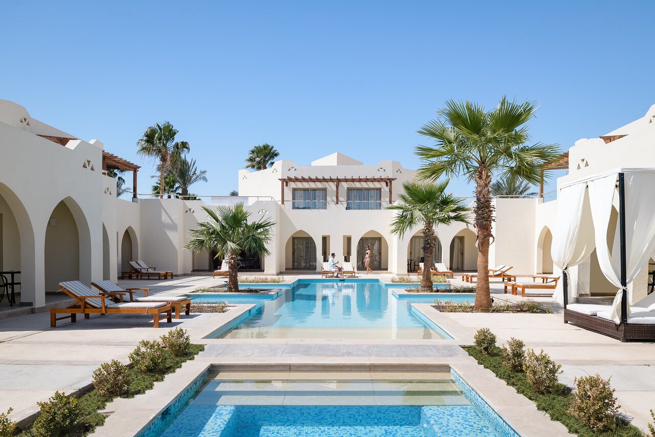 Xanadu Club Makadi Bay baseins ar palmu kokiem un atpūtas zonu.