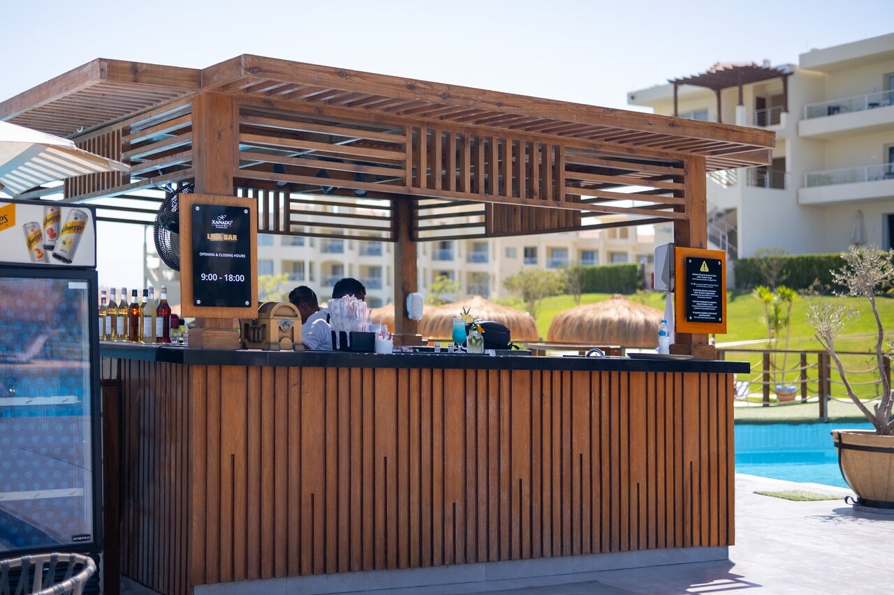 Xanadu Club Makadi Bay poolside bar with wooden decor.