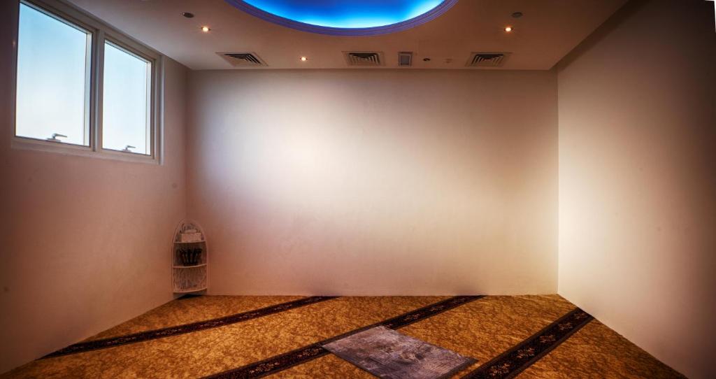 Lūgšanu telpa Rose Park Hotel Al Barsha ar paklāju un logu.