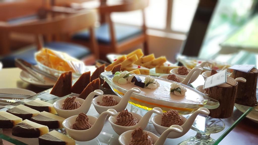 Deserta galda izvēle ar dažādiem saldumiem, tostarp šokolādes un krēma kūkām, kā arī augļu un dekoratīviem elementiem. Ideāli piemērots svinībām un svētkiem.