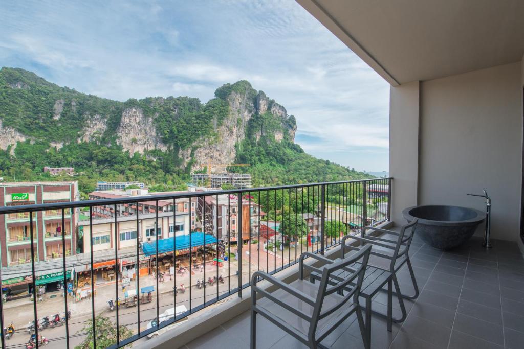 Skats no Sugar Marina Resort Cliffhanger Aonang balkona uz kalniem un pilsētu.