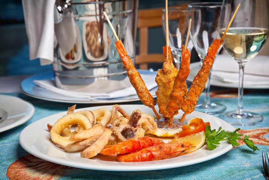 Jūras velšu šķīvis Baia del Porto restorānā ar baltvīnu.