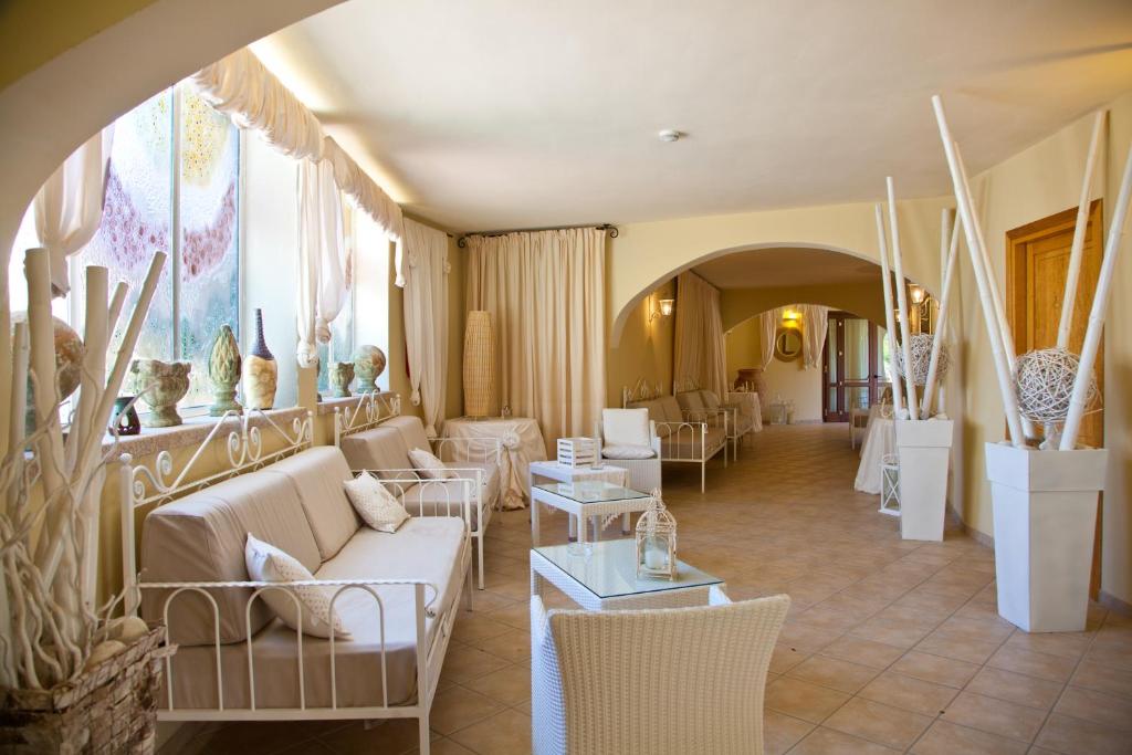 Baia del Porto viesnīcas elegantā atpūtas telpa ar gaišu interjeru.