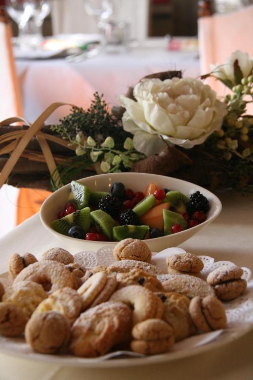 Svaigi cepti gardumi un augļu salāti, kas pasniegti dekoratīvā traukā, radot patīkamu atmosfēru. Burvīgs galda izkārtojums ar ziediem un ēdieniem.