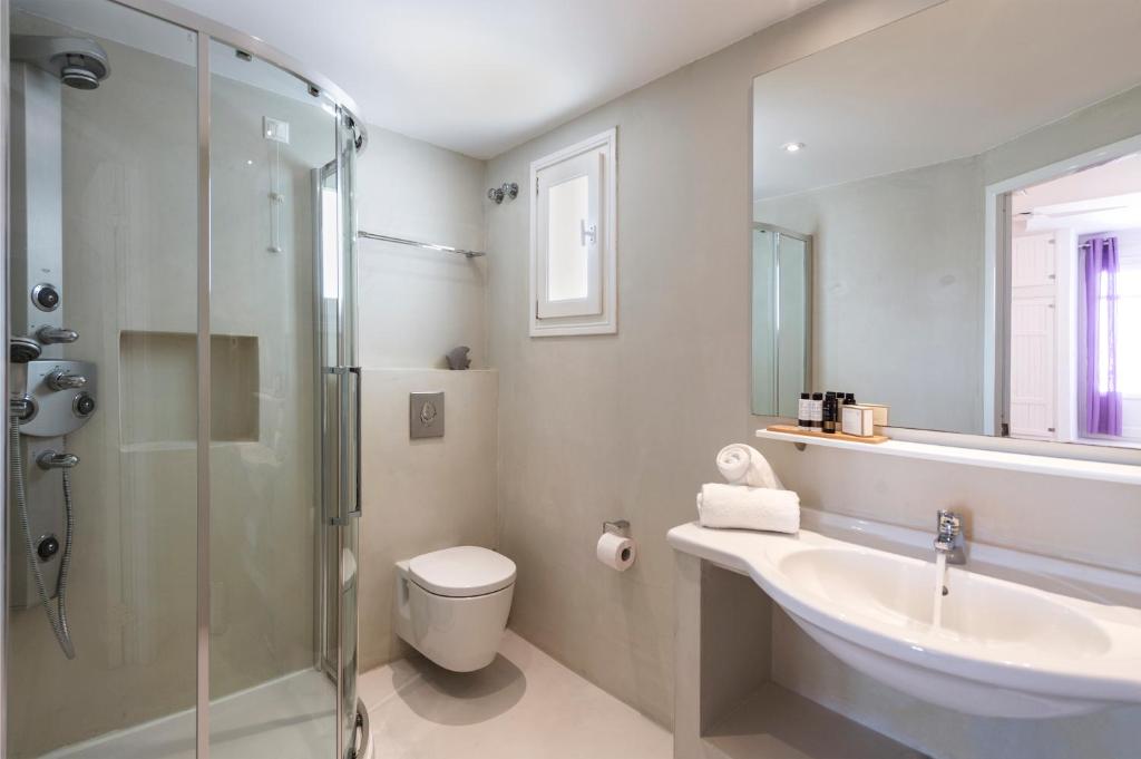 Mūsdienīgs vannas istabas interjers ar dušu, izlietni un elegantu dizainu, kurā ir pieejami higiēnas piederumi un dvieļi.